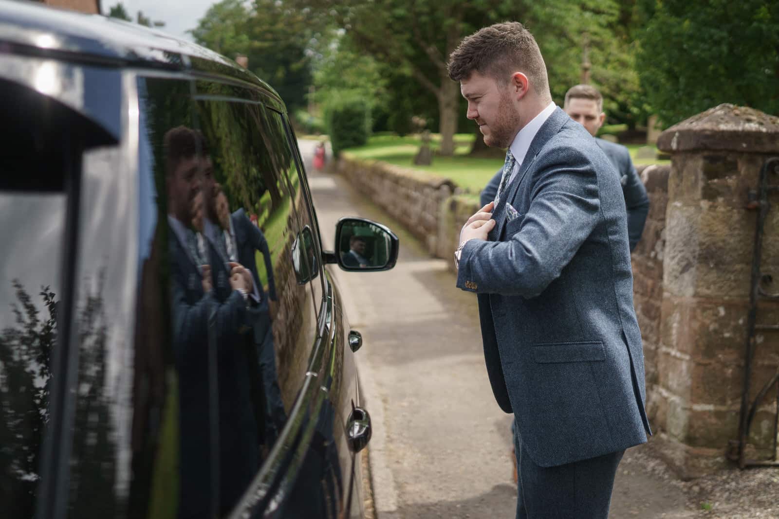 a man in a suit is getting ready in a car.