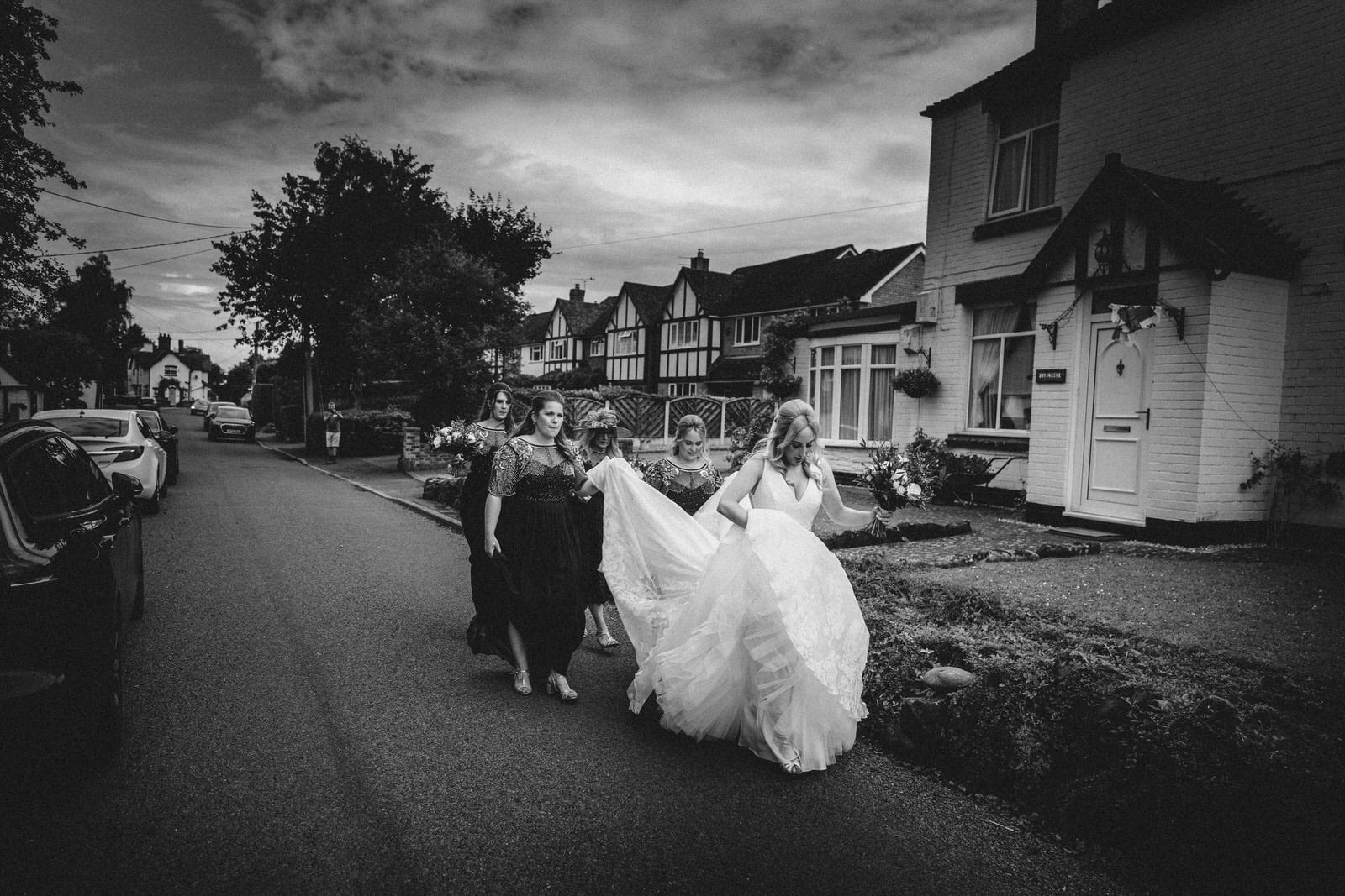 a bride and her bridesmaids walking down the street.