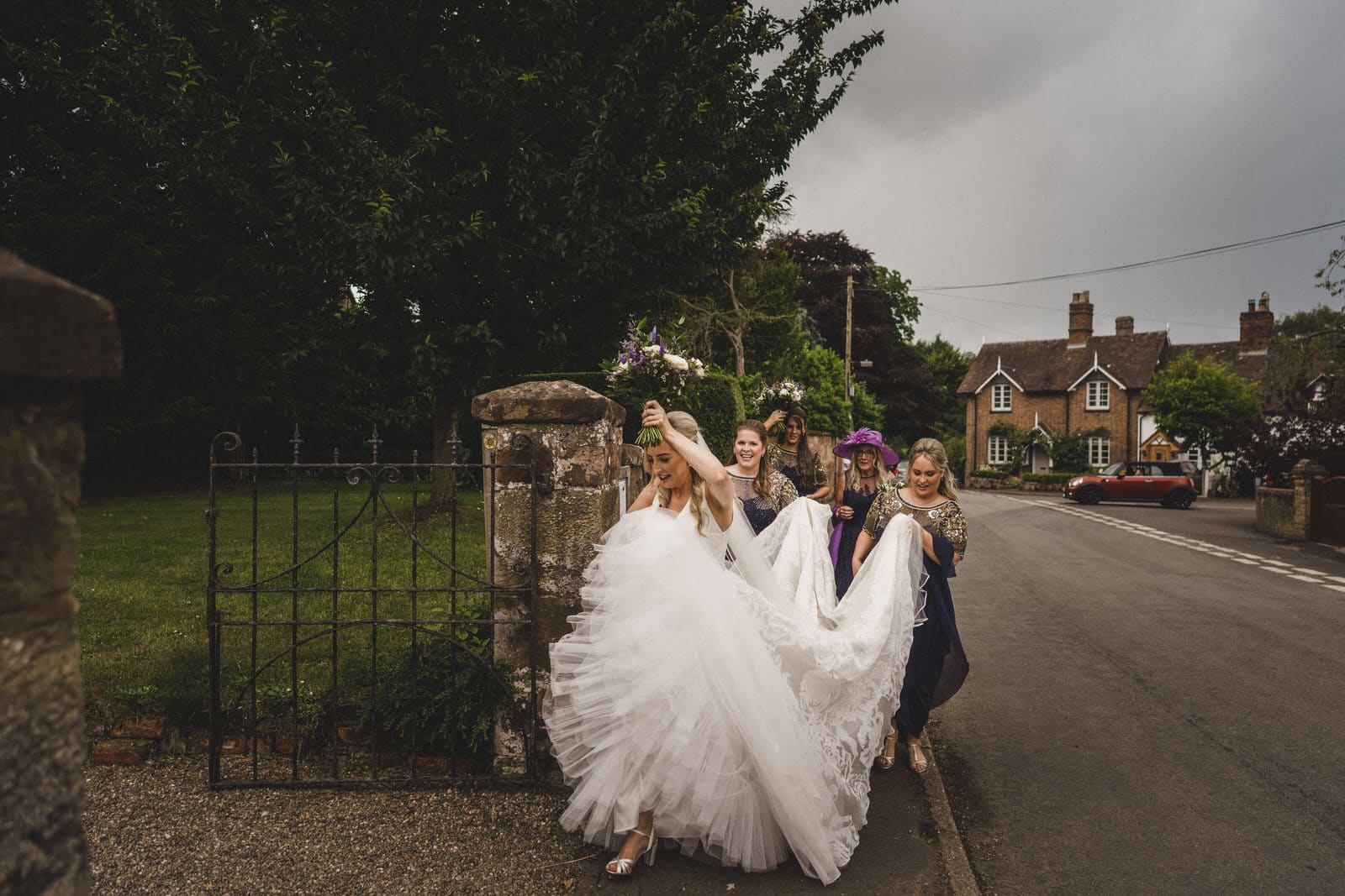 a bride and her bridesmaids walking down the road.