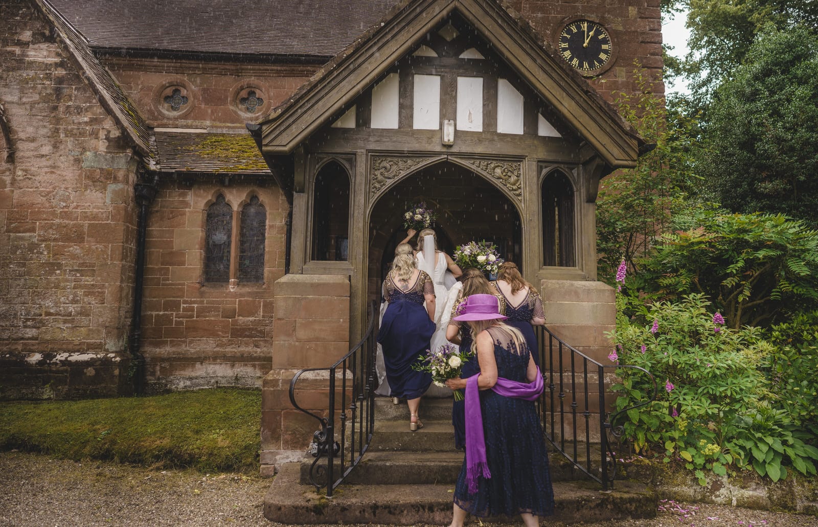 a bride and her bridesmaids walking down the steps of a church.