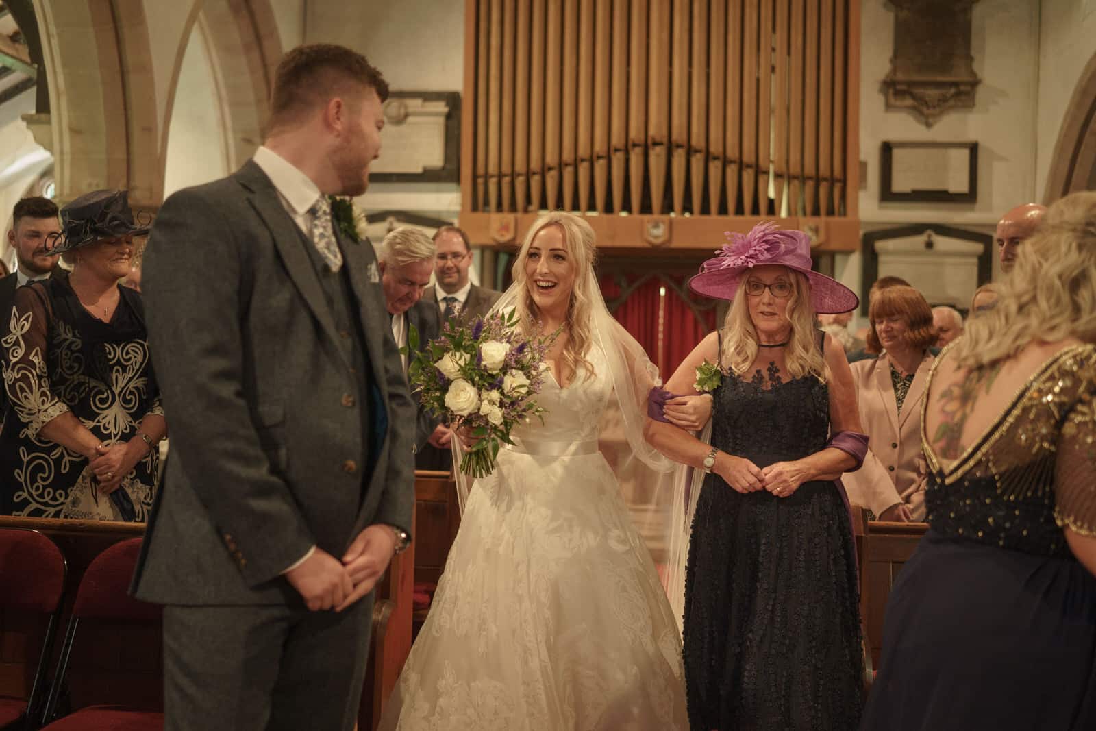 a bride and groom walking down the aisle in a church.