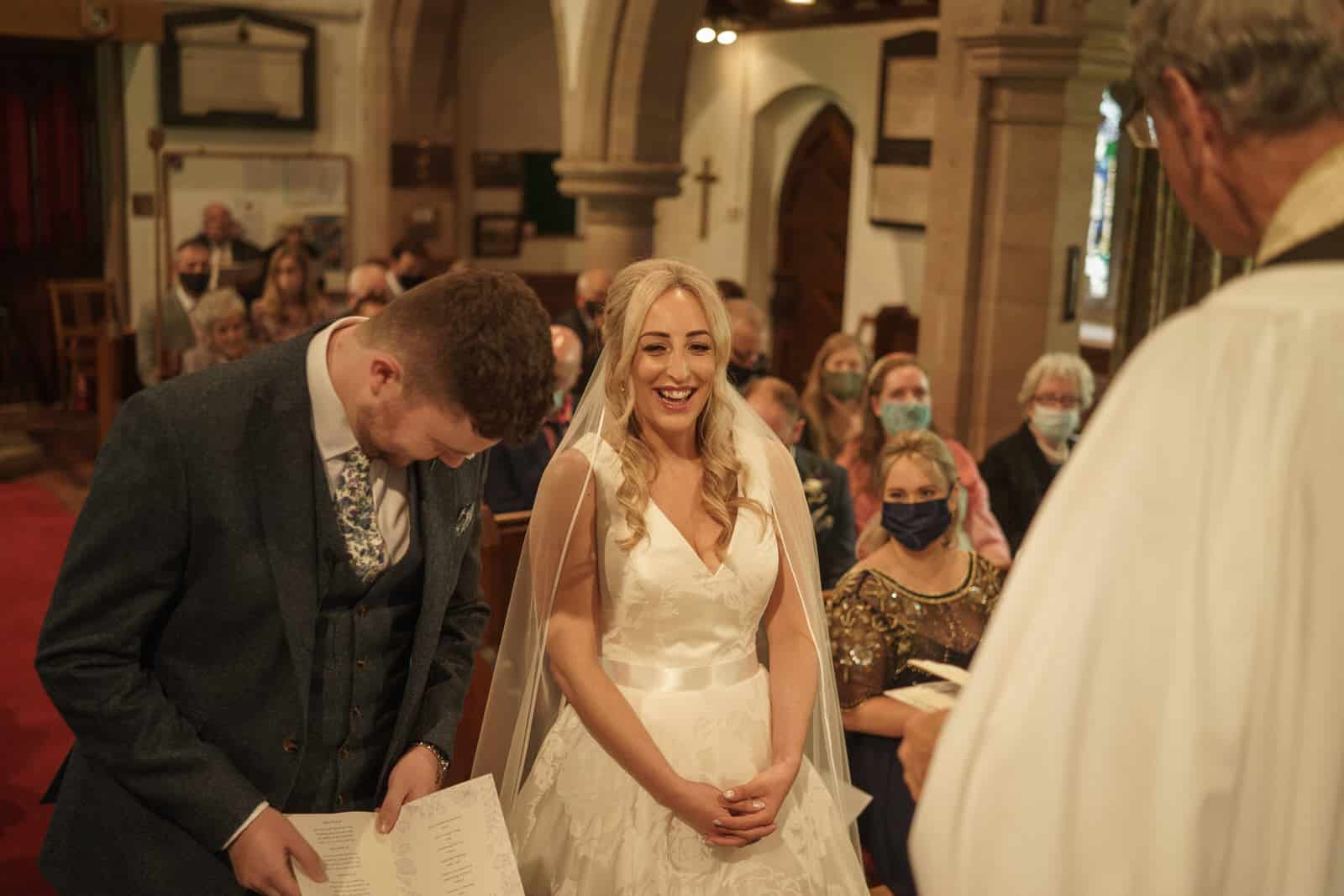 a bride and groom look at each other during their wedding ceremony.