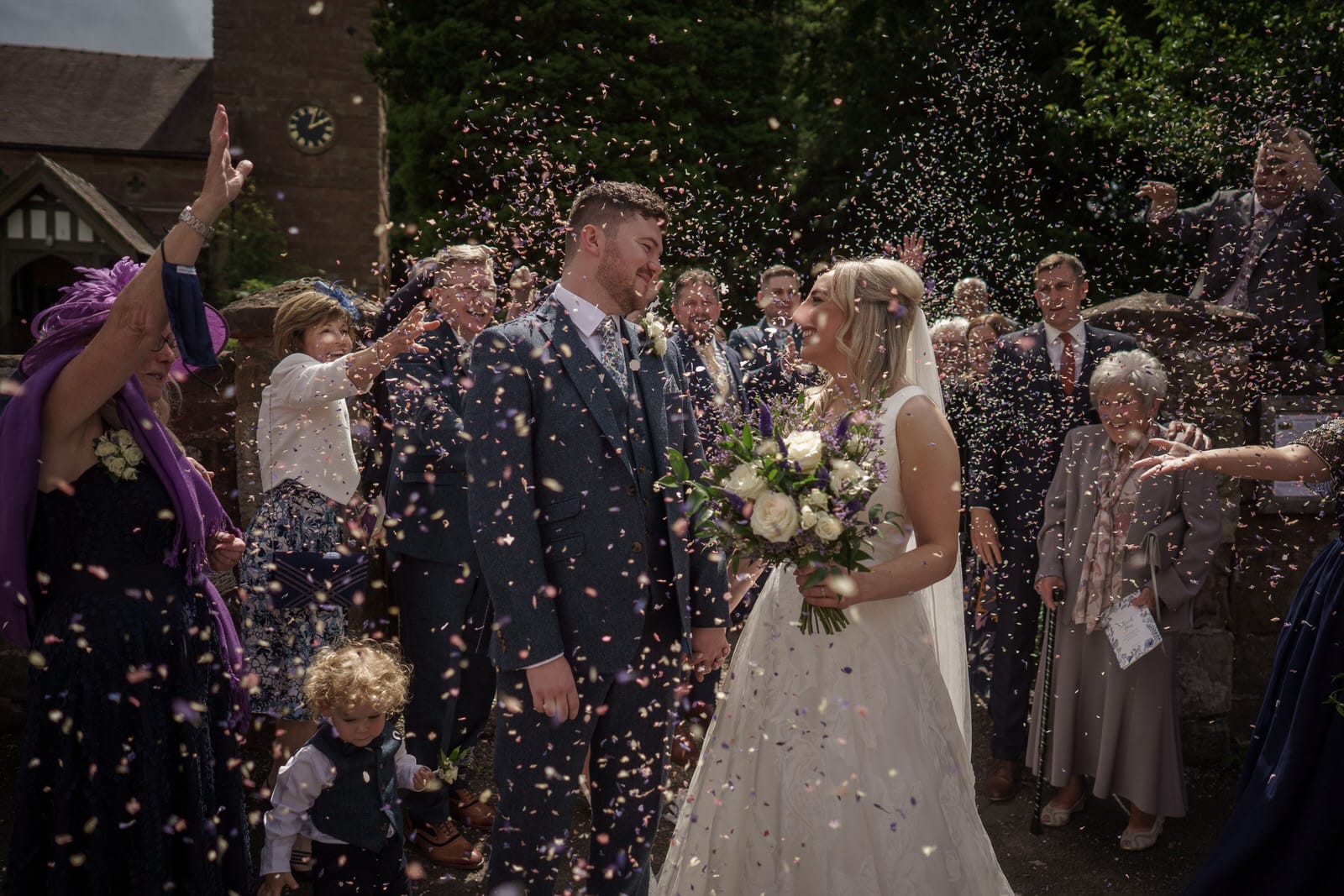 a bride and groom are being confettied at their wedding.