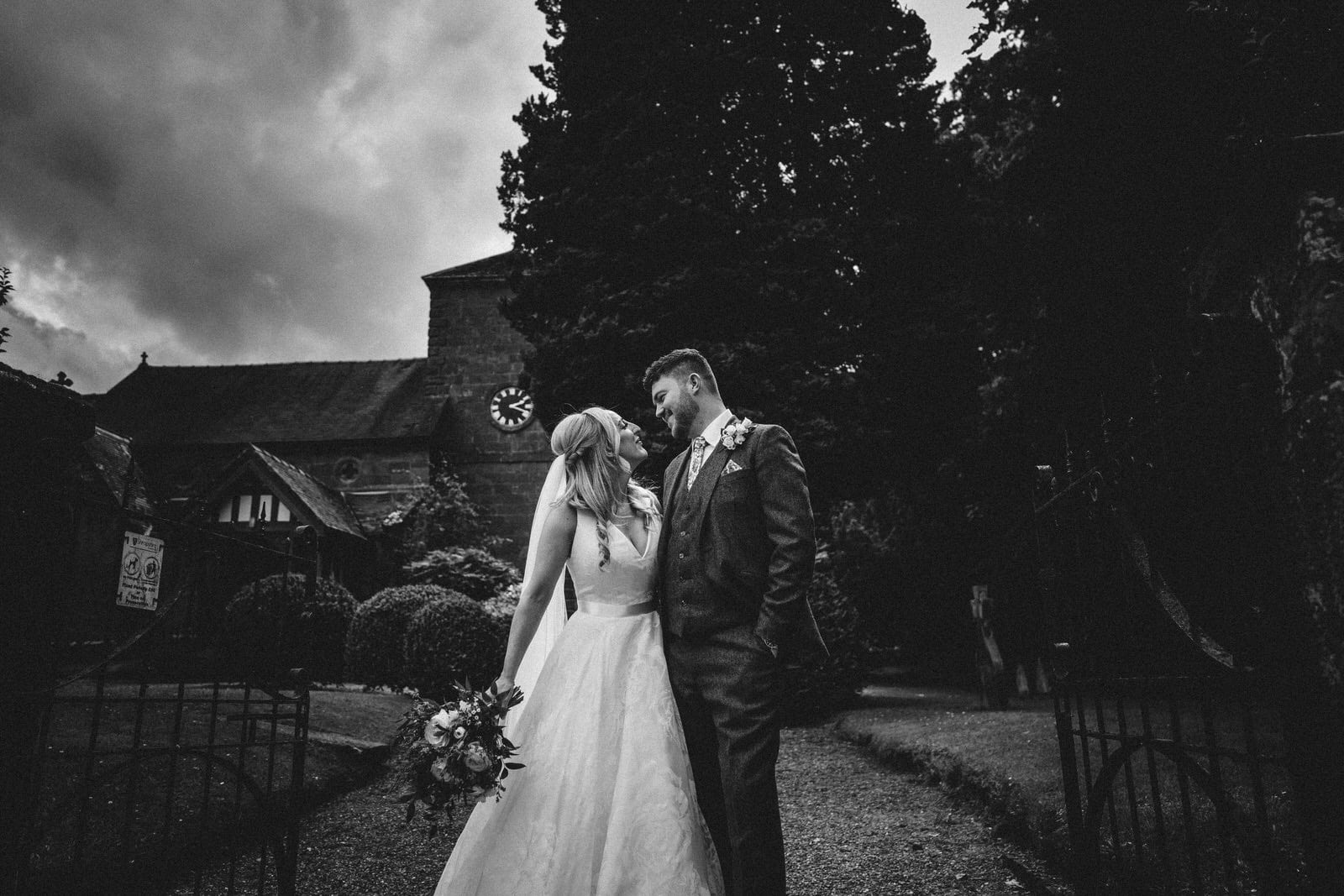 a bride and groom kissing in front of a church.