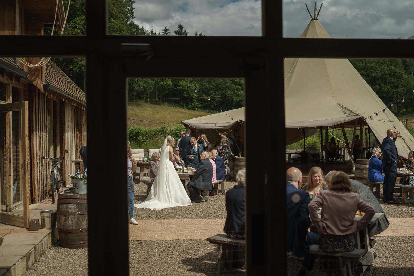a bride and groom standing outside of a teepee tent.