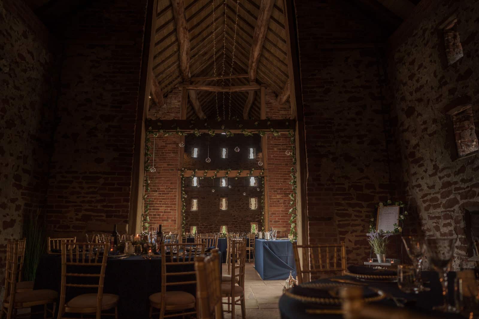 a wedding reception in a barn with tables and chairs.