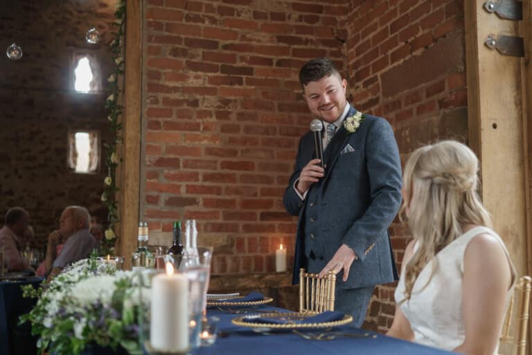 a man giving a speech at a wedding.