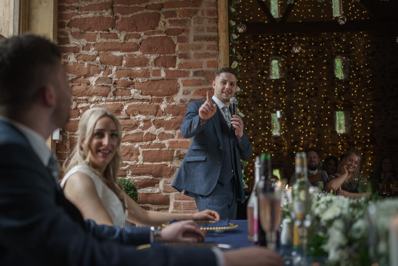 a man giving a speech at a wedding reception.