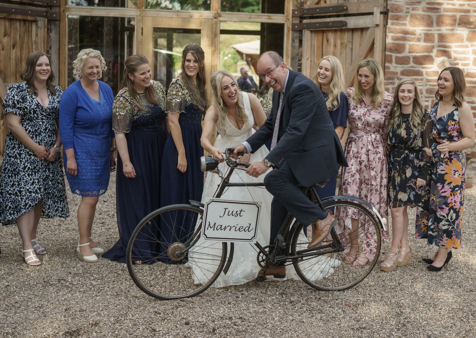 a group of bridesmaids posing on a bicycle.