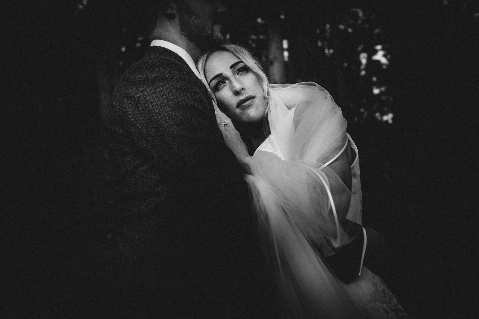 a bride and groom hugging in the dark.