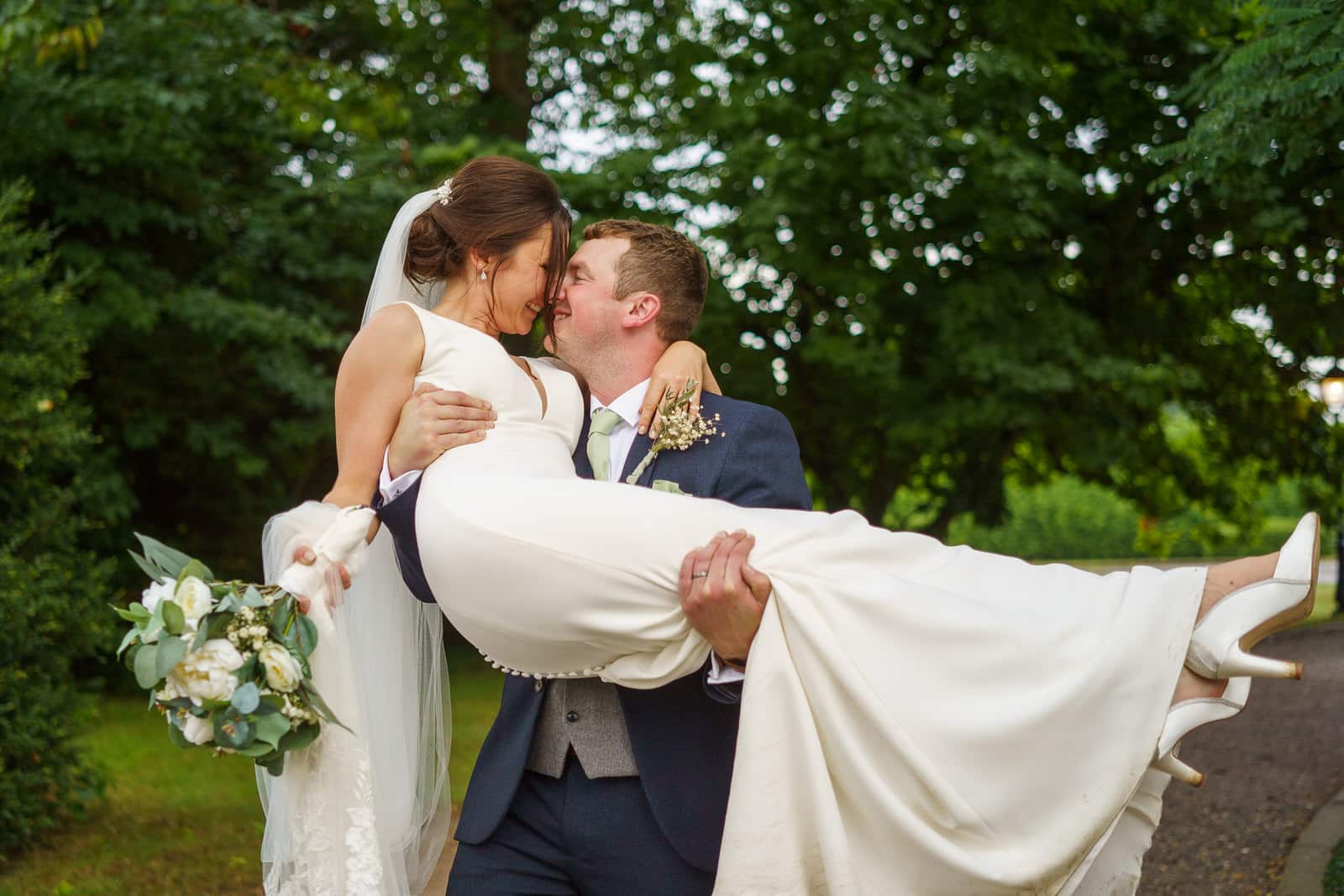 a bride and groom hugging each other on a path.