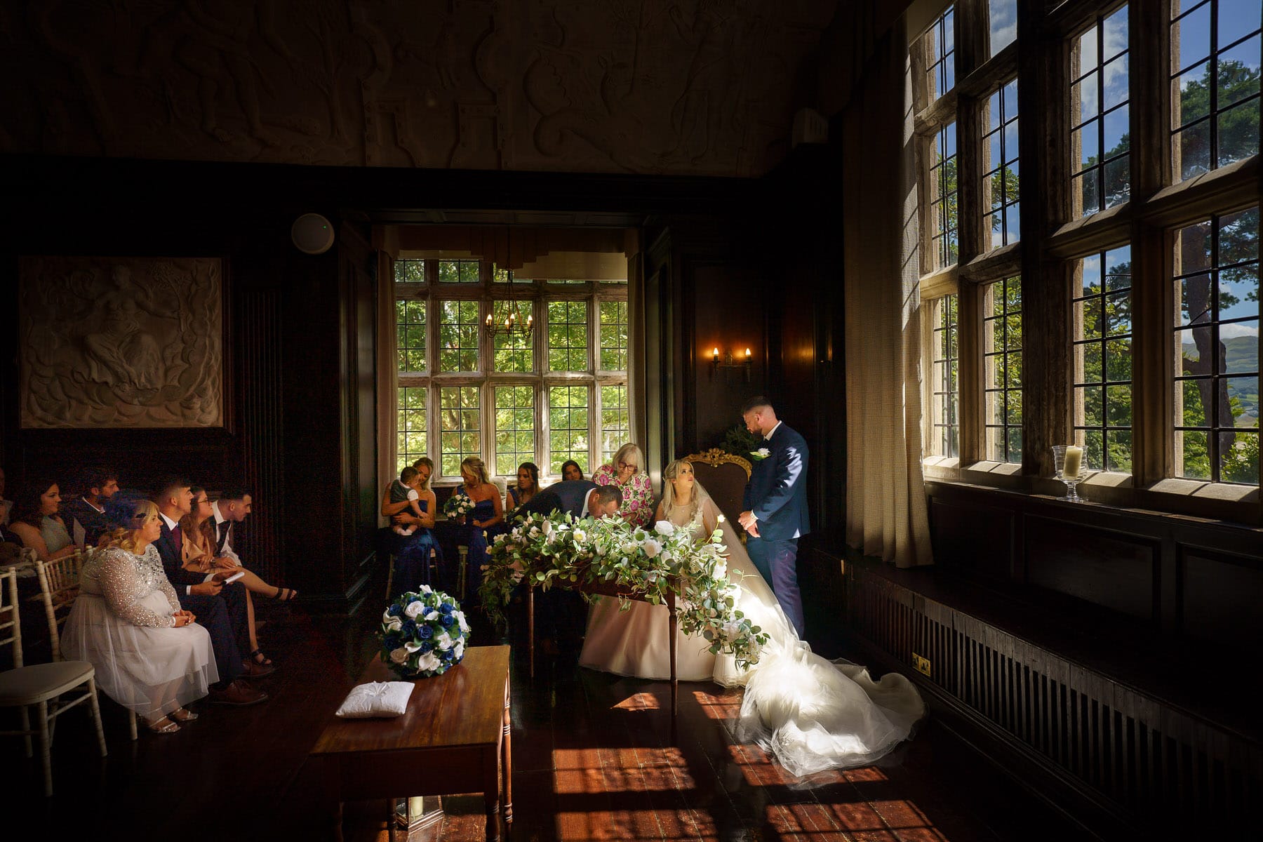 a bride and groom standing in front of a large window.