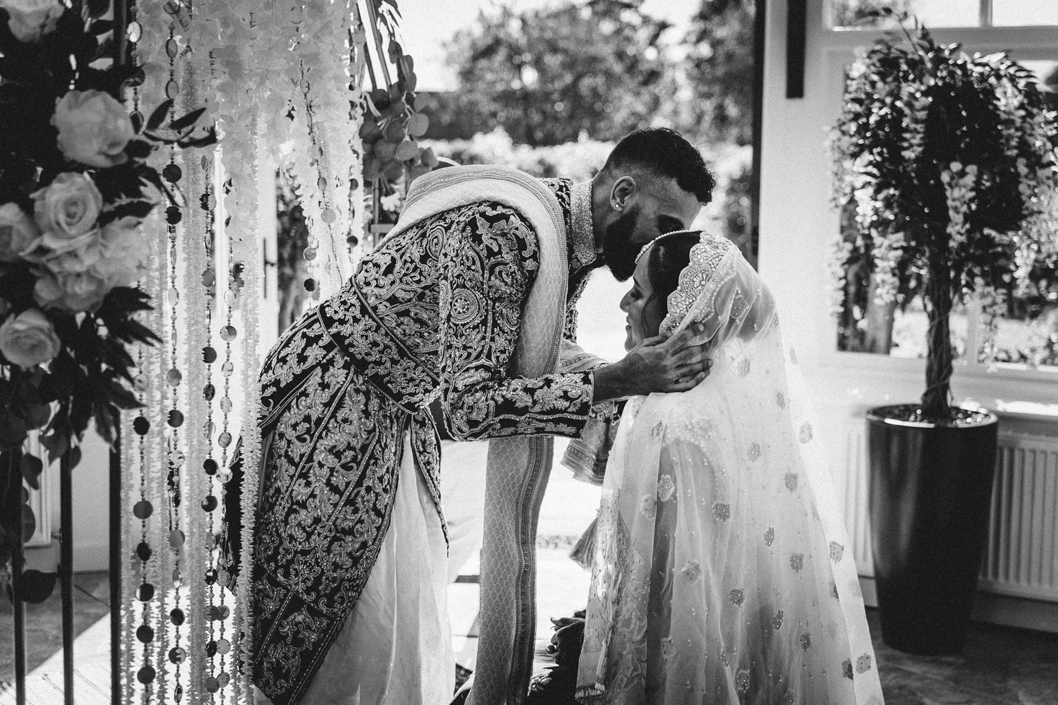 a bride and groom hugging in front of a door.