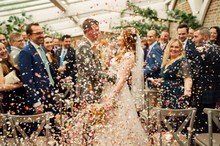 a bride and groom are surrounded by confetti at their wedding.