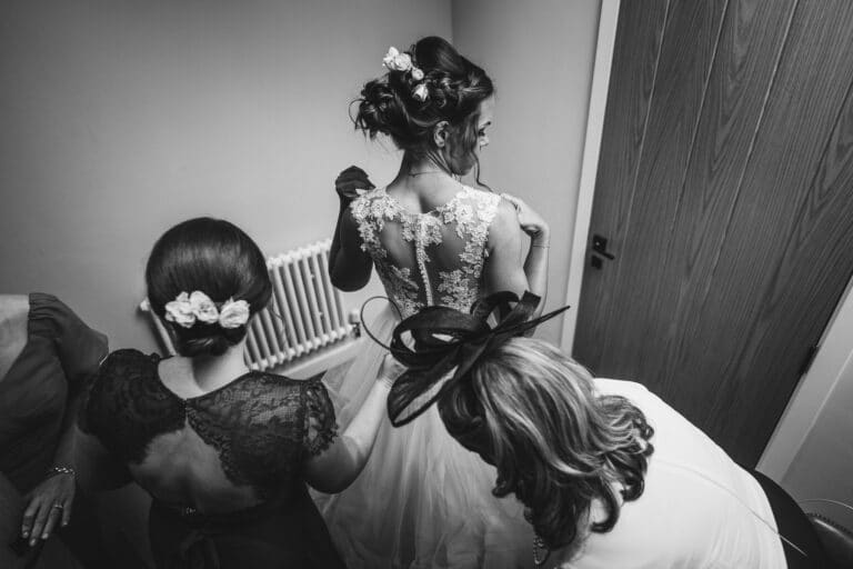 a bride is getting ready in a black and white photo at foxtail barns.