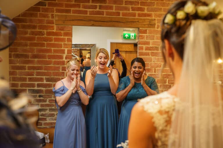 a bride and her bridesmaids admire themselves in the mirror at foxtail barns.