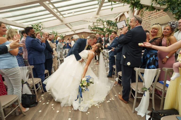 a bride and groom exchange a loving kiss during their wedding ceremony at foxtail barns.