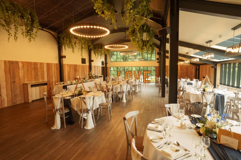 a foxtail barns with tables and chairs set up for a wedding reception.