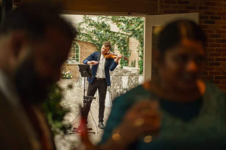 a man playing the violin at a wedding reception held at foxtail barns.