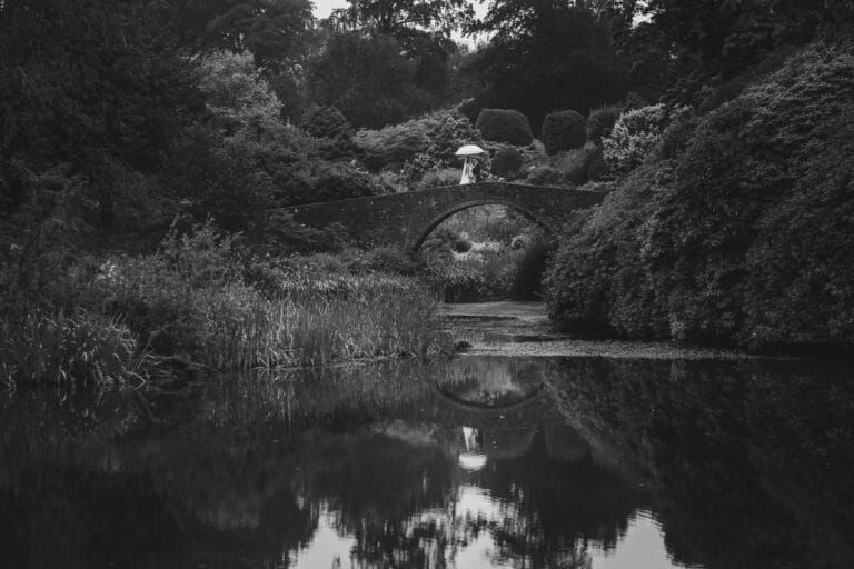 a black and white photo of a bridge over a river.