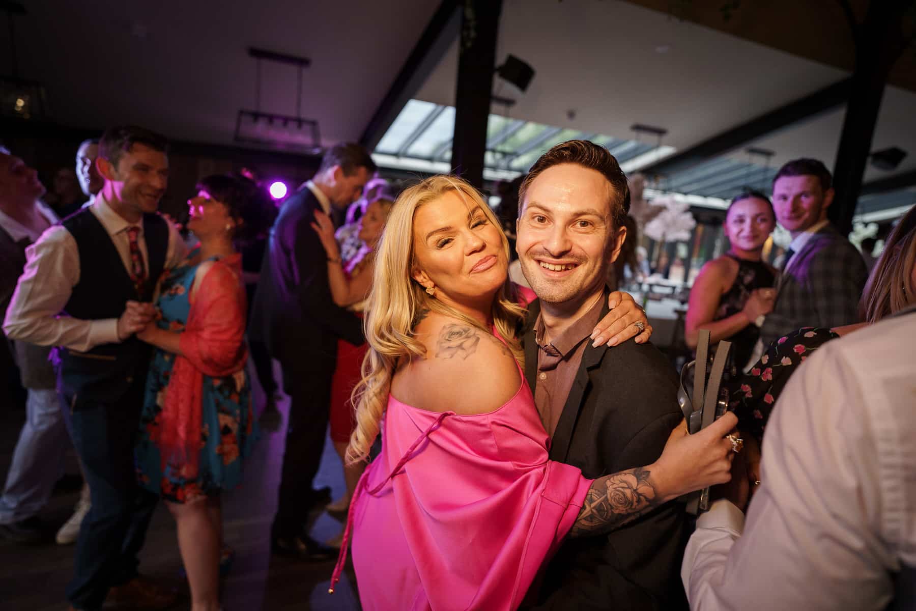 a man and woman embracing joyfully at a foxtail barn wedding reception.