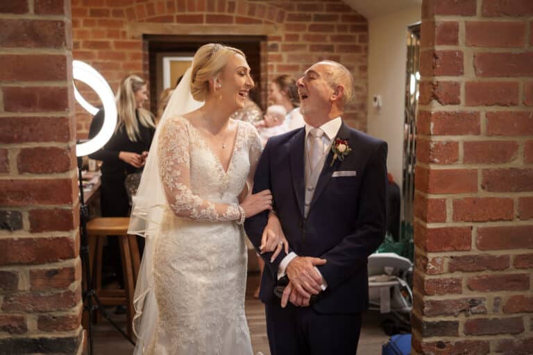 a bride and groom laughing in front of the mirror at foxtail barns.
