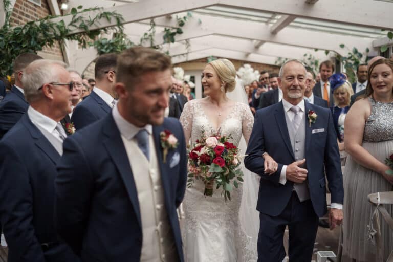 a bride walking down the aisle at foxtail barns with her father.