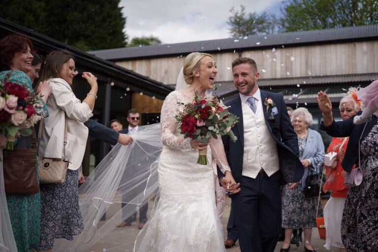 a bride and groom exchange their vows at the charming foxtail barns, celebrating their union surrounded by joyful confetti.
