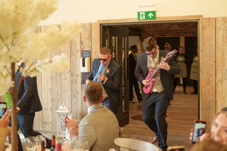 a group of men playing guitars at a wedding reception at foxtail barns.
