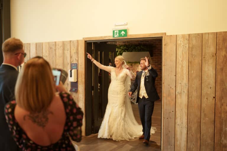 a bride and groom standing at the entrance of foxtail barns, a charming rustic venue.
