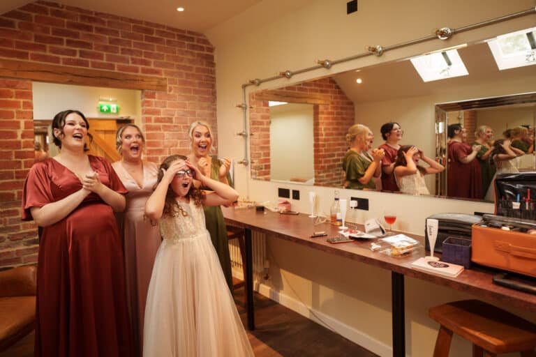 bride and bridesmaids at foxtail barns, posing in front of a mirror.