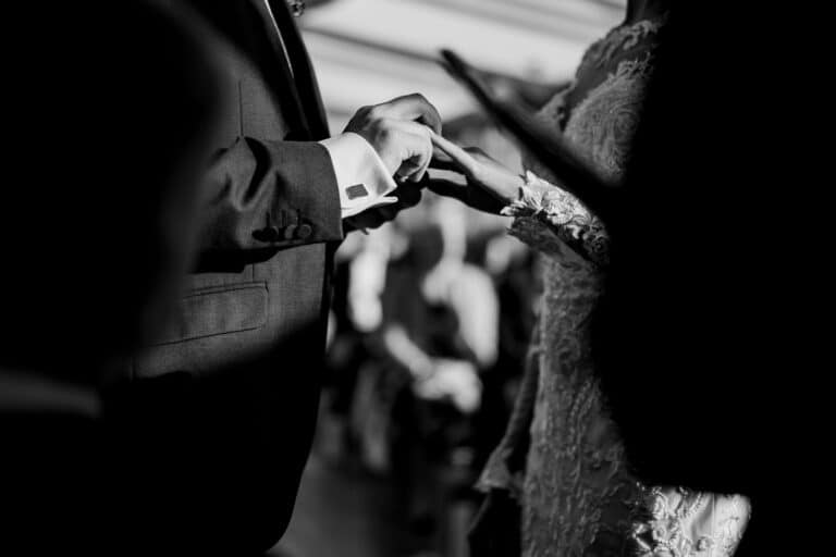 a bride and groom are holding hands during their wedding ceremony at foxtail barns.