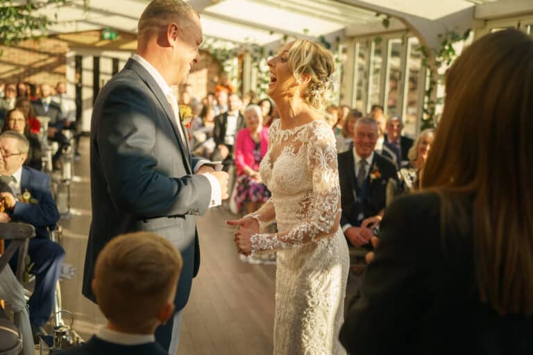 a bride and groom share a kiss at the beautifully decorated foxtail barns during their wedding ceremony.