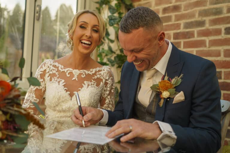a couple signing the wedding certificate at foxtail barns.