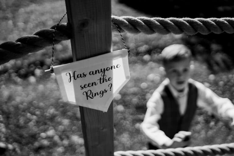 a black and white photo of a boy standing on a rope in foxtail barns.