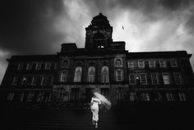 on her wedding day, a bride gracefully descends the steps of a large building.