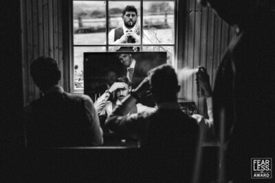 a man is taking a picture of himself in front of a window showcasing the artistry of pbartworks photography.